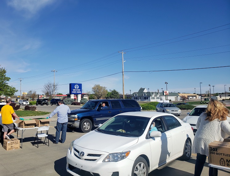 GC team distributing hand sanitizer to cars