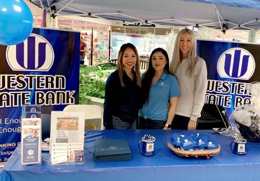 Dodge City mortgage loan officers posing behind booth