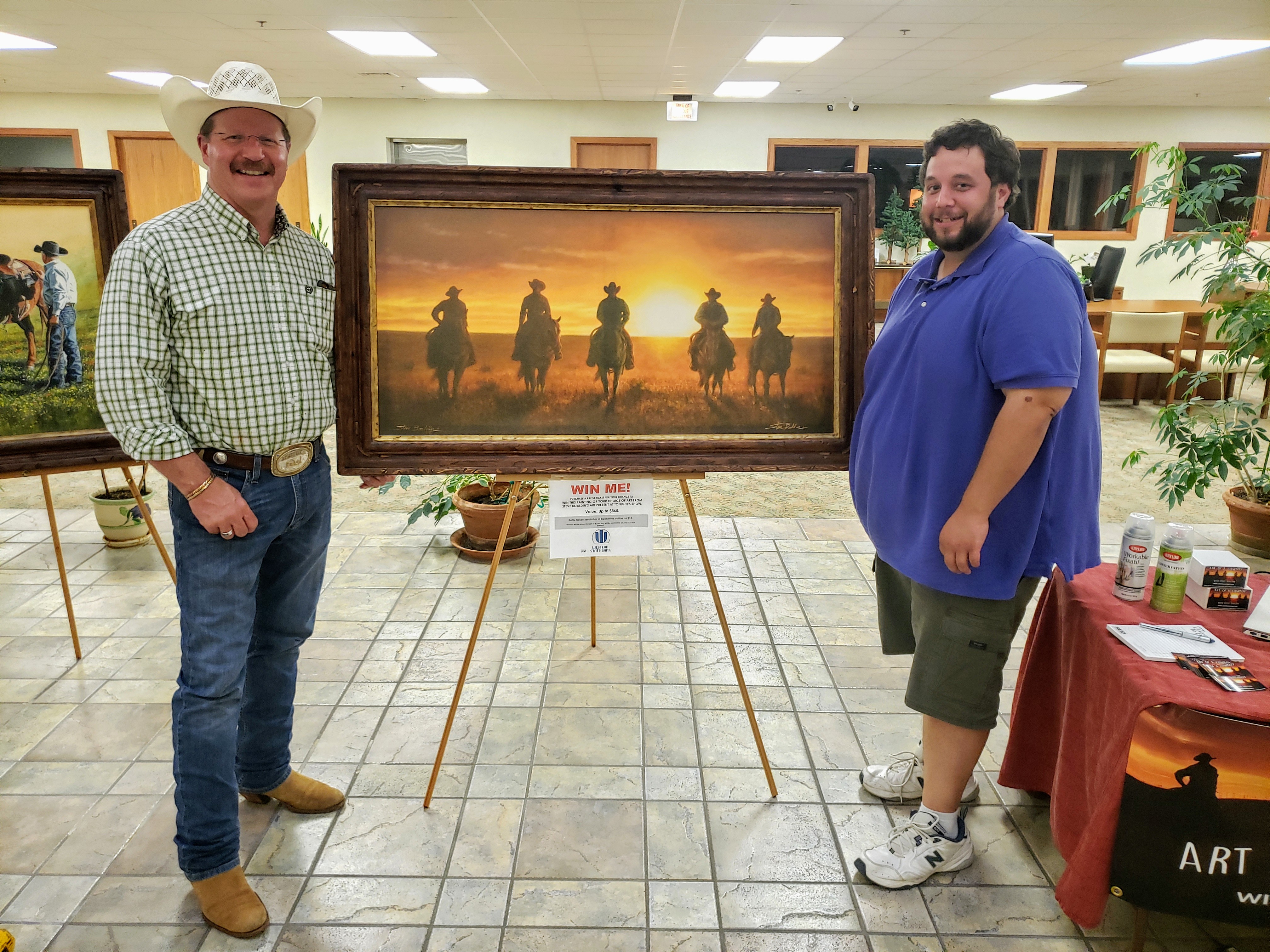 Alt Text: Featured artist Steve Boaldin with raffle winner Josh Roesener.