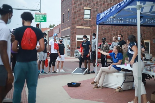 students crowd around cornhole boards at wsb tent