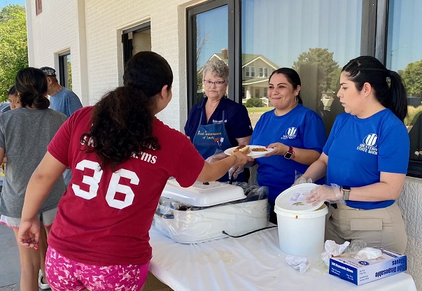 leoti staff serves bbq attendees