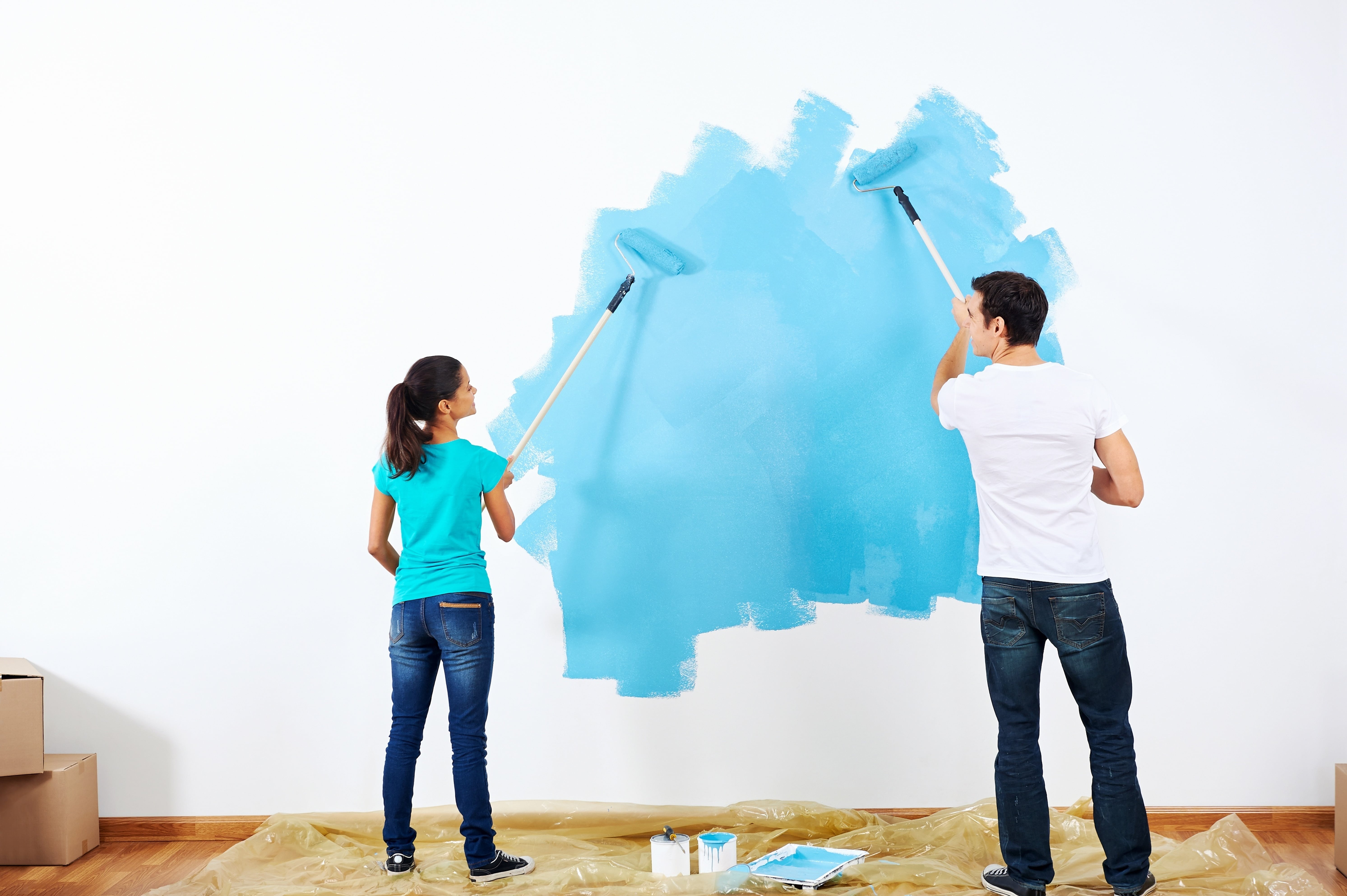 couple painting a wall in new home.