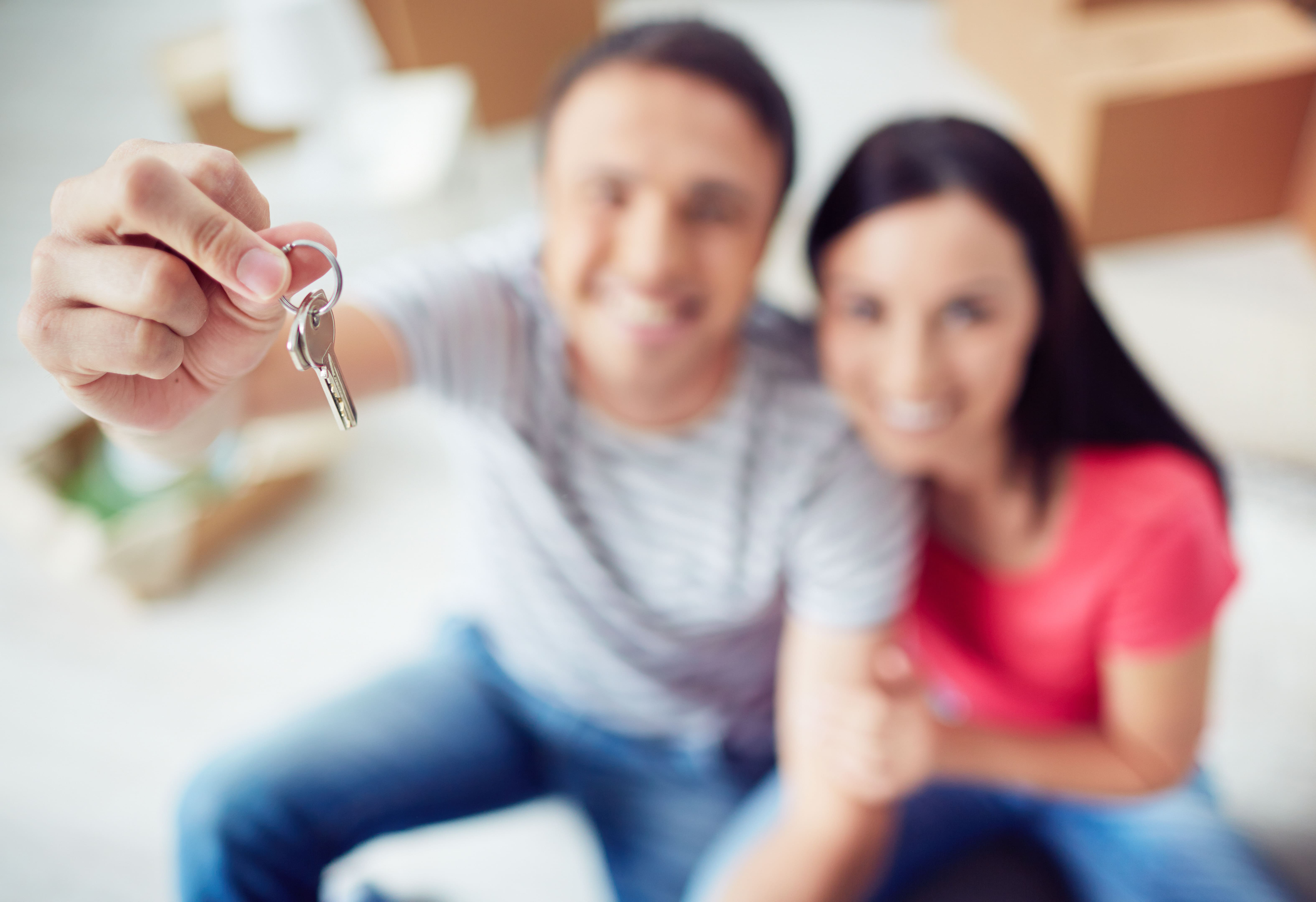 couple holding keys to new house. 