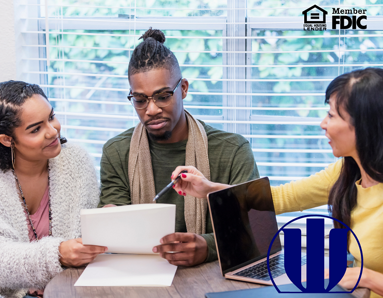 couple signing loan paperwork in an office