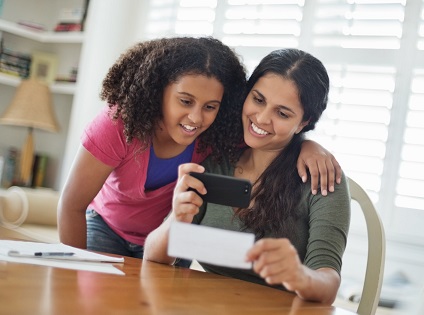 mom and daughter making mobile deposit